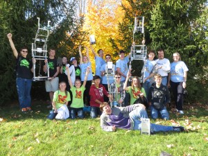 The VEX Vortex, Raptors, and Dragons display their trophies and robots.